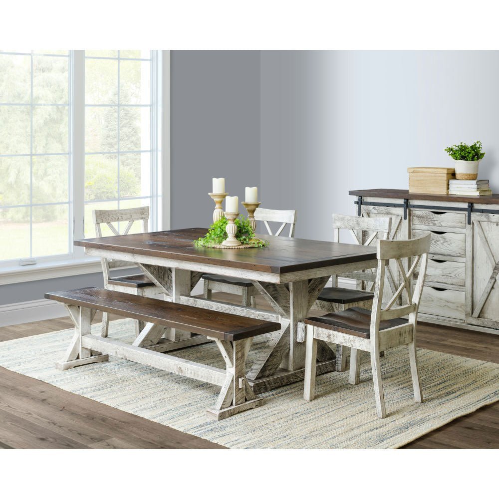 Farmhouse dining room with a whitewashed trestle table, X back chairs, bench and barn door sideboard