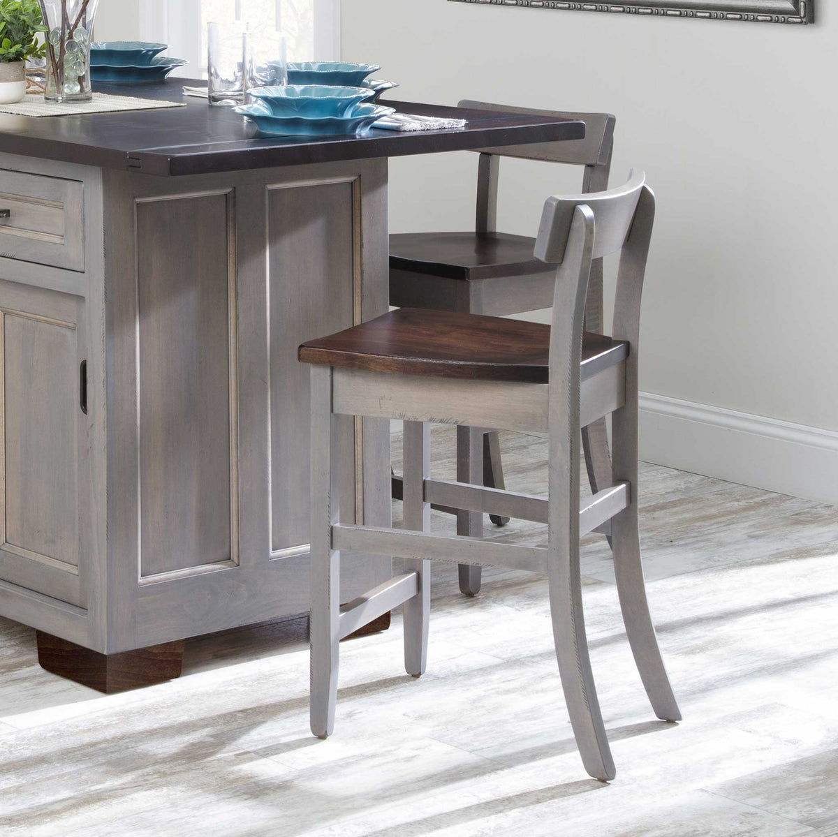 Gray painted low back bar chairs with dark brown wood seats and slim curved backs at a gray island