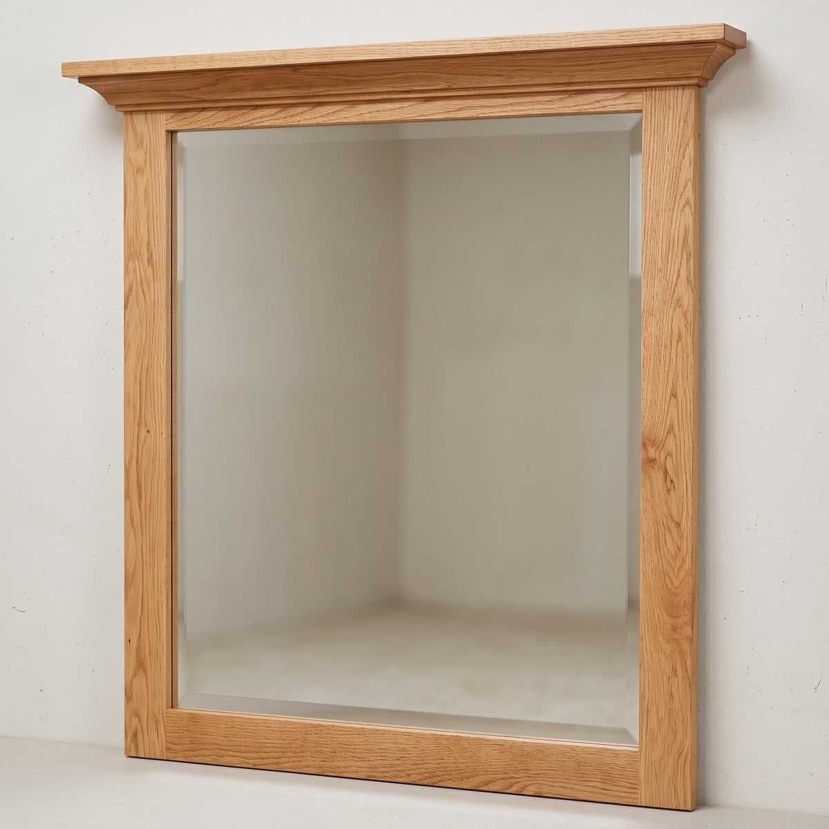 A square wall mirror with a natural oak wood frame, shown mounted on a plain off-white wall.