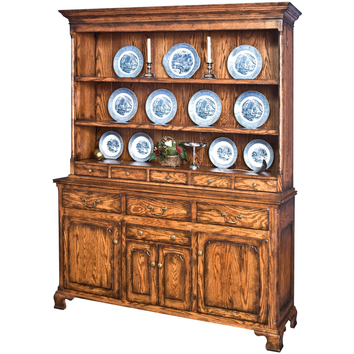 Oak English buffet with a plate rack hutch displaying blue and white china above drawers and paneled doors