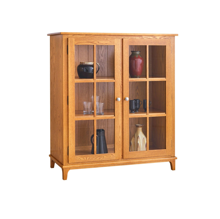 Golden oak two door display cabinet with glass panes, three interior shelves and tapered feet on white