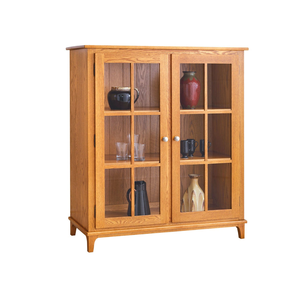 Golden oak two door display cabinet with glass panes, three interior shelves and tapered feet on white