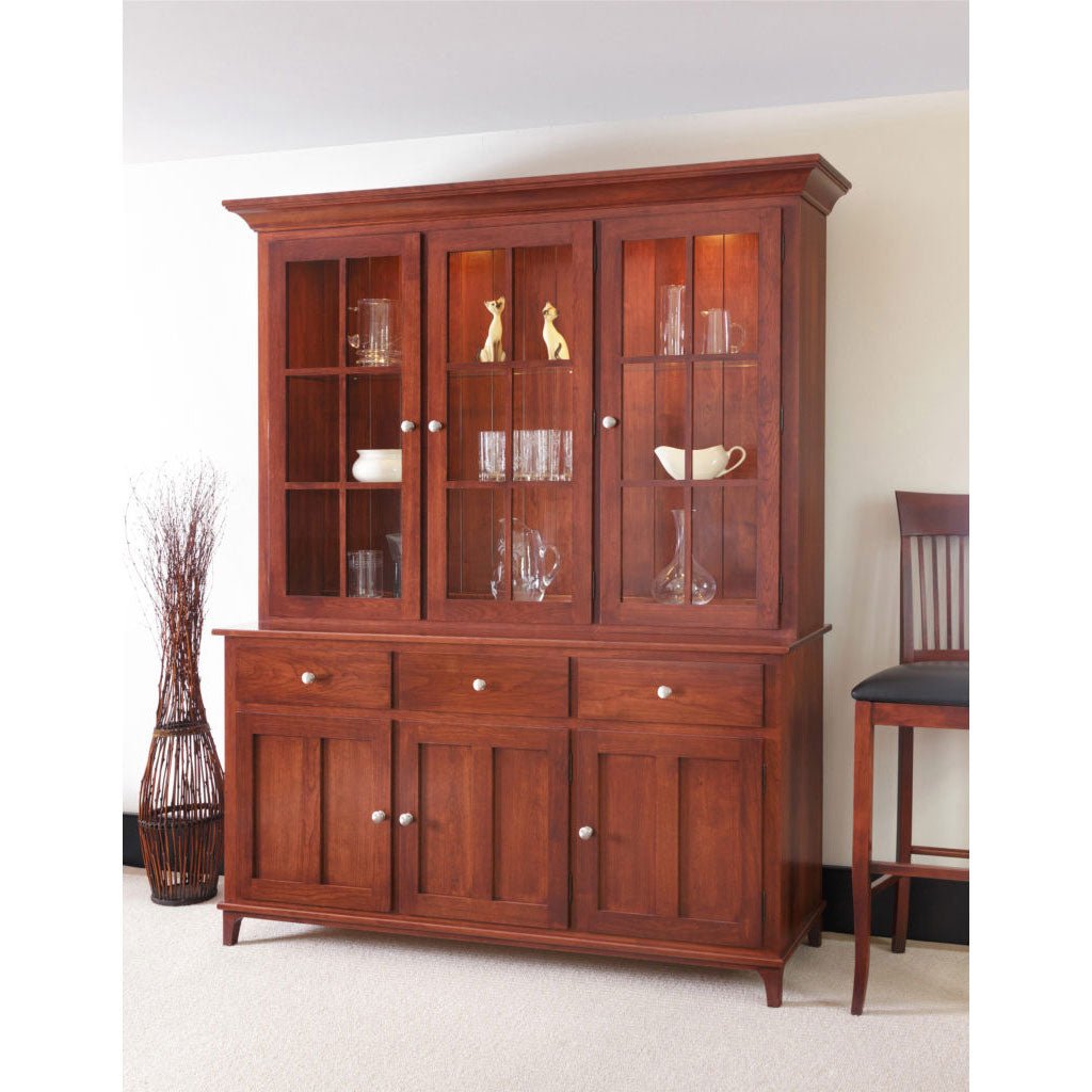 Cherry three door dining hutch with lighted glass display shelves above three drawers and paneled doors