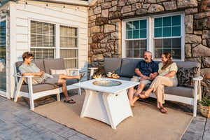Fernandina poly cushion sectional sofa with fire table, white with gray cushions, stone patio