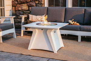 Fernandina poly outdoor fire table, white, lit, with sectional on stone patio - lifestyle (other pieces sold separately)