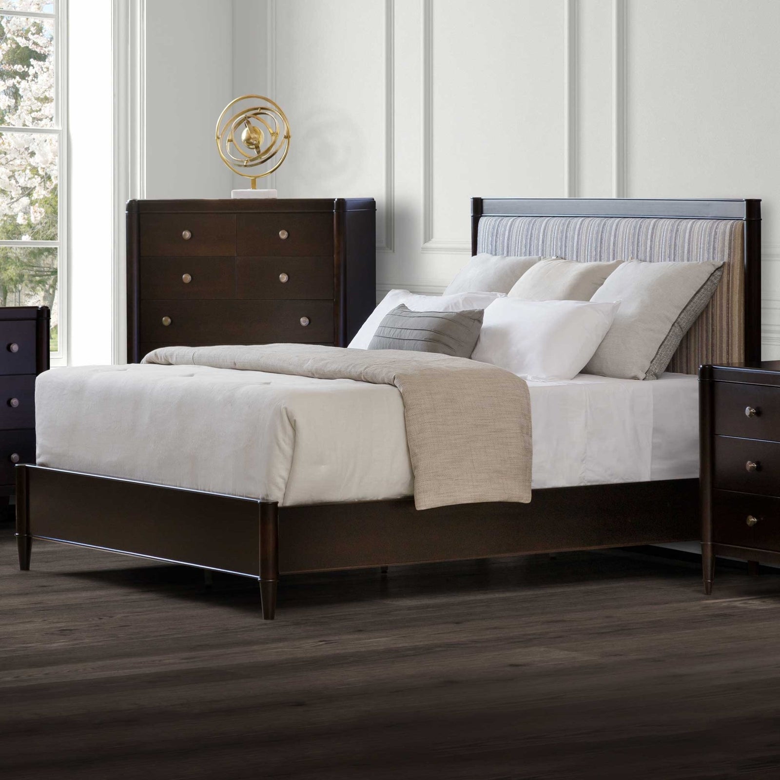 Upholstered bed with a striped fabric headboard in an espresso frame, flanked by a chest and nightstand