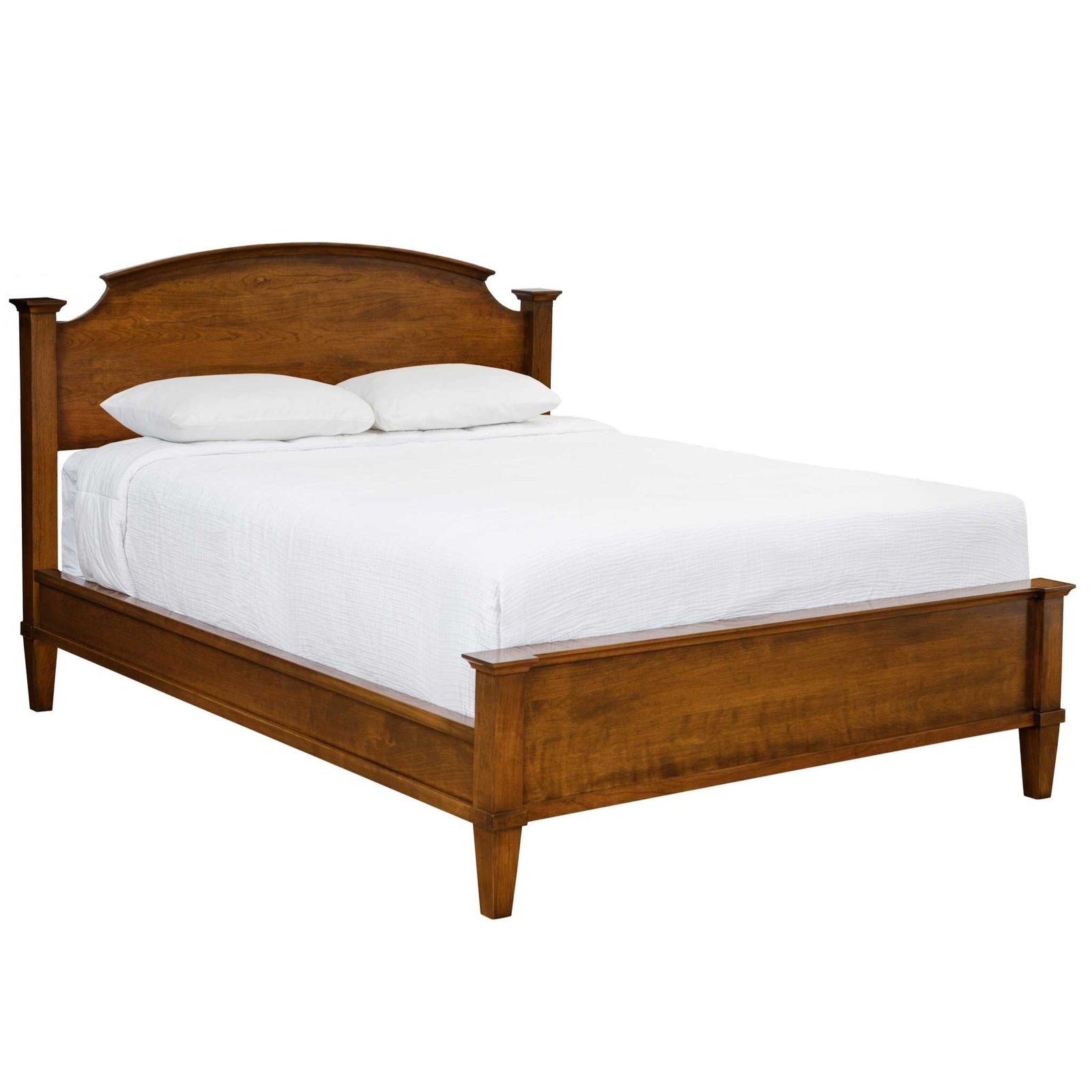 Cherry arched headboard bed with a paneled footboard and tapered legs, styled with linen bedding and a nightstand