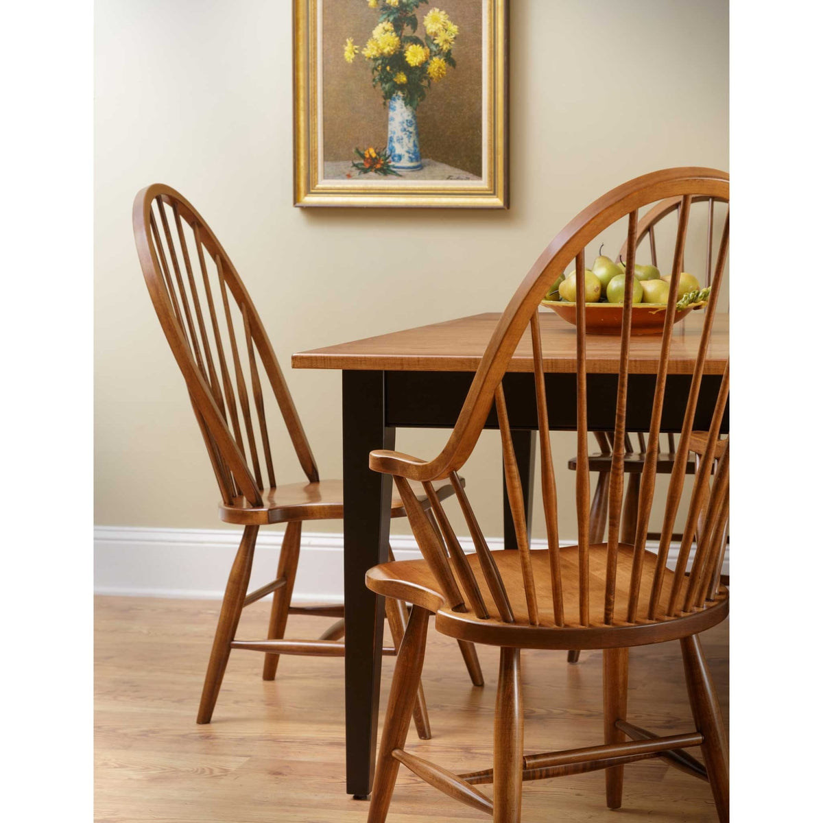 High back Windsor spindle dining chairs in warm cherry, side and arm chair paired with a black based farmhouse dining table