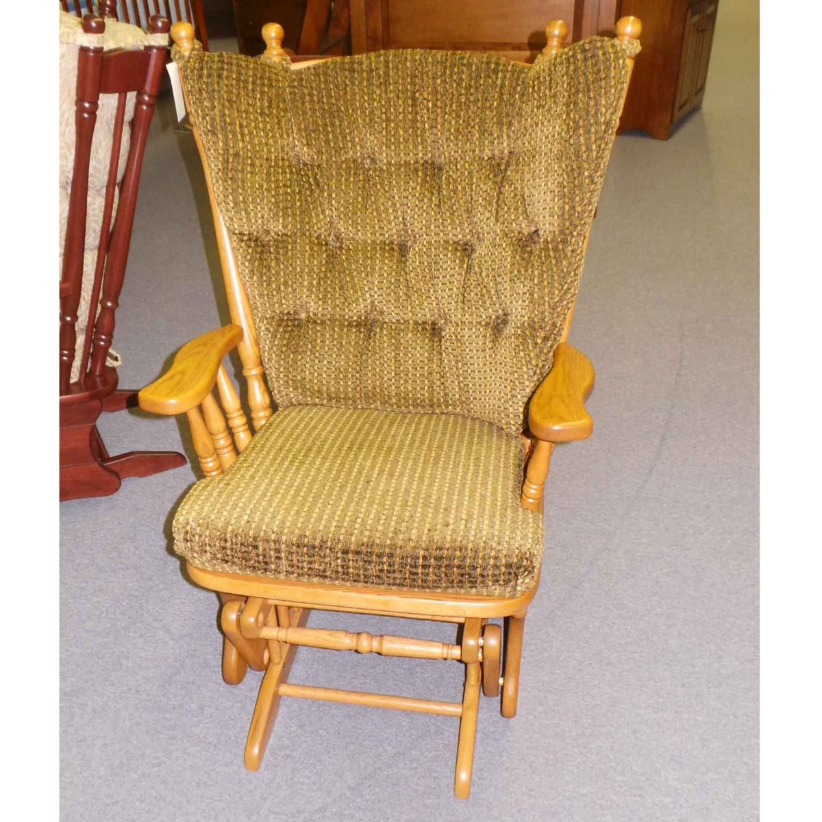 Golden oak high back glider rocker with olive green textured tufted cushions and wide paddle arms