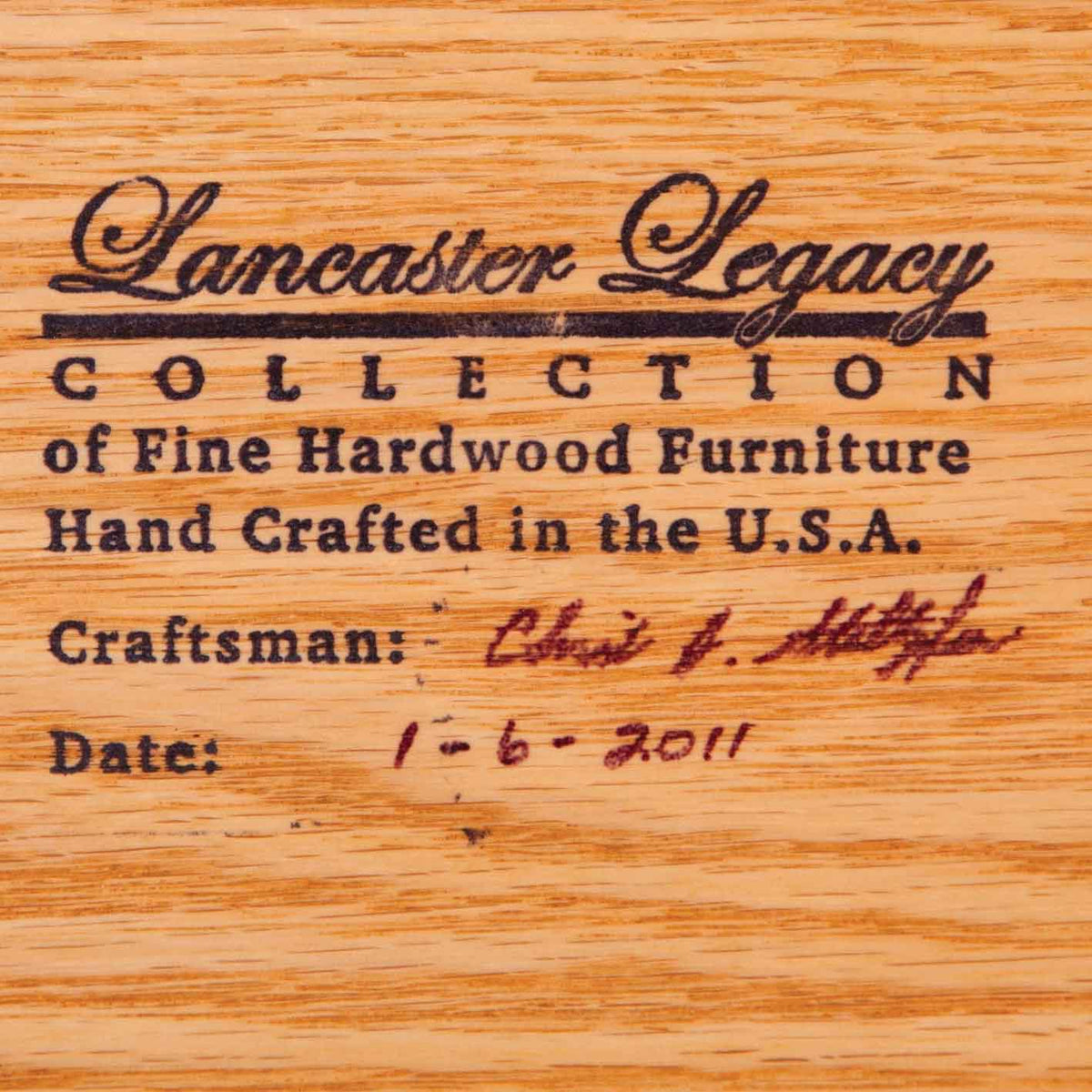 Branded maker's stamp on oak reading Lancaster Legacy Collection of Fine Hardwood Furniture, hand crafted in the USA