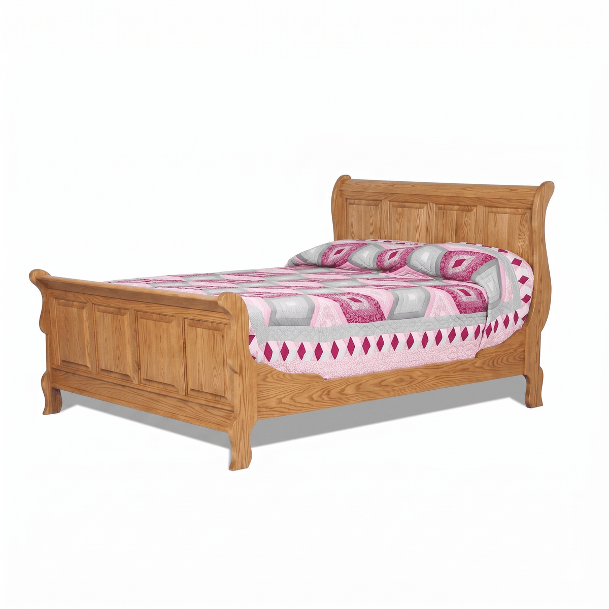 Golden oak sleigh bed with four-panel scrolled headboard and matching footboard, made up with a pink patchwork quilt