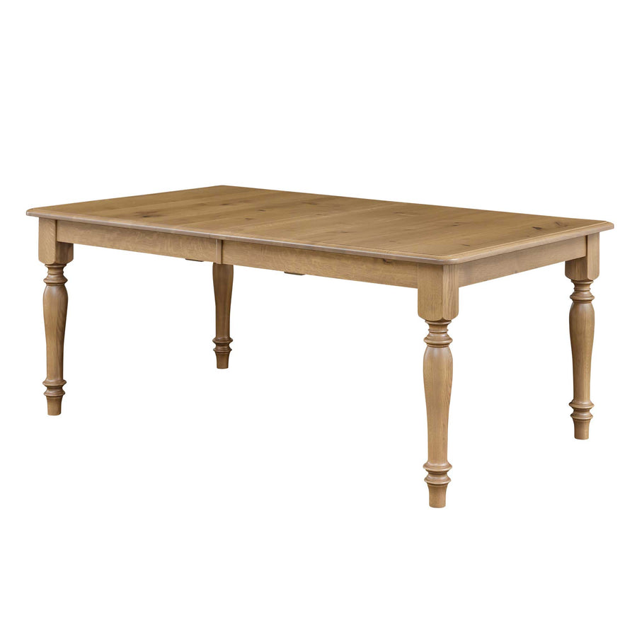 Rectangular solid oak farmhouse dining table with chunky turned legs in a light natural finish, shown with the extendable leaf seam visible