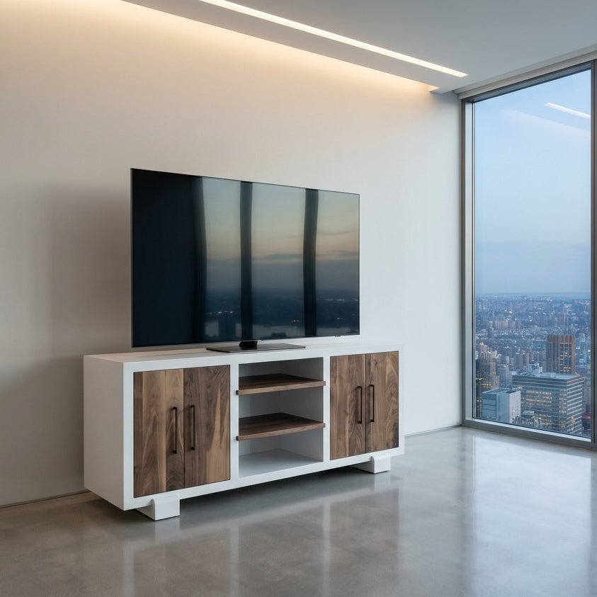 A modern white TV stand with wood cabinet doors and open shelving, holding a large flat-screen television, set in a minimalist room with a large window overlooking a city skyline.
