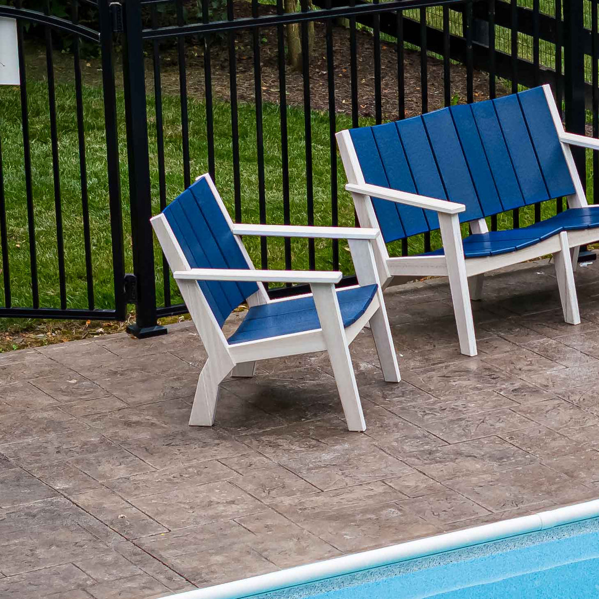 White and blue poly patio arm chair and matching loveseat beside a swimming pool