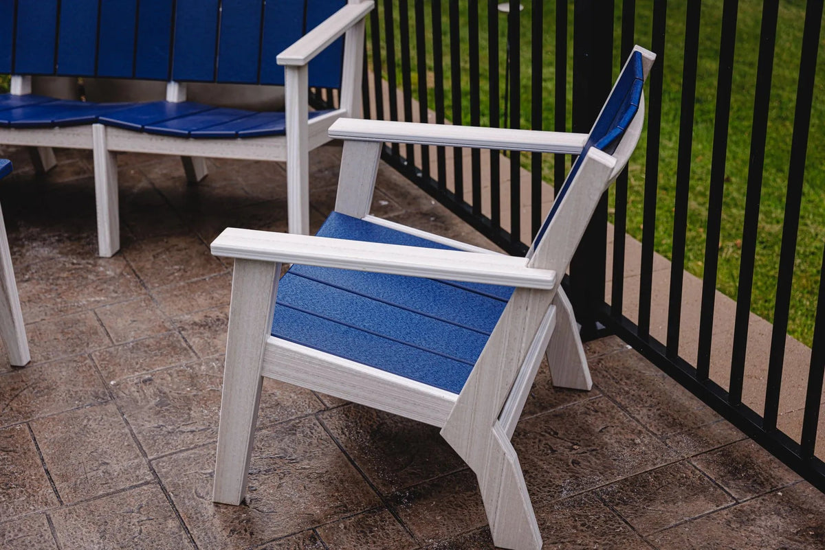 Angled view of the white and blue poly patio chair with the three seat sofa in the background