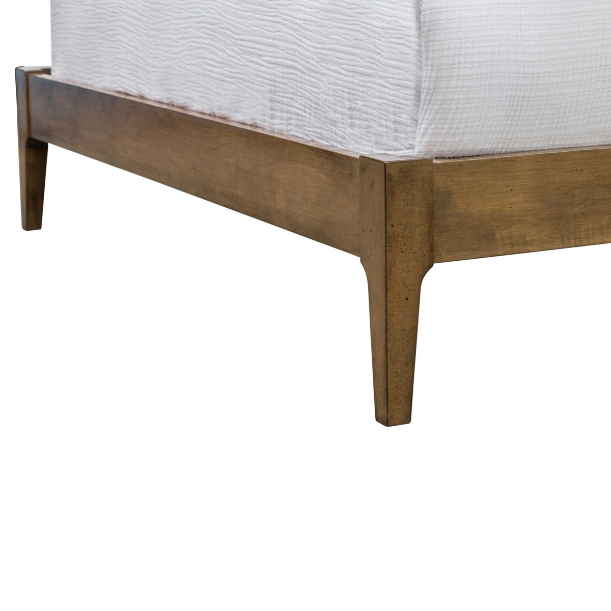 Foot corner of the light wood bed frame showing the slim side rail, mitered joint and tapered leg