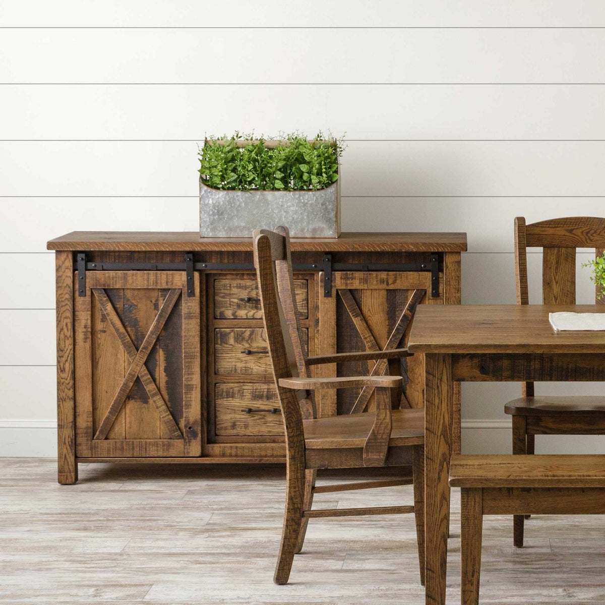 Rustic oak barn door server with sliding X panel doors on black hardware and three center drawers