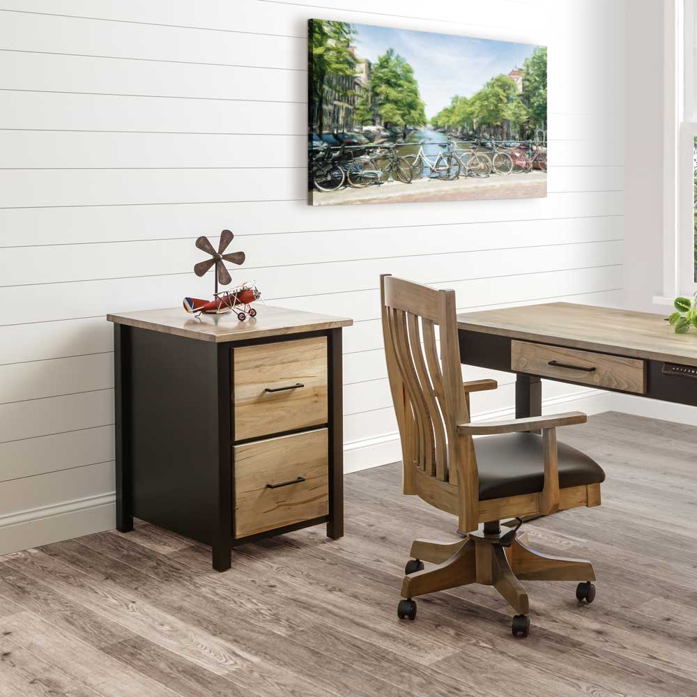 Two tone file cabinet with black frame and light maple drawers next to a matching desk and wood office chair