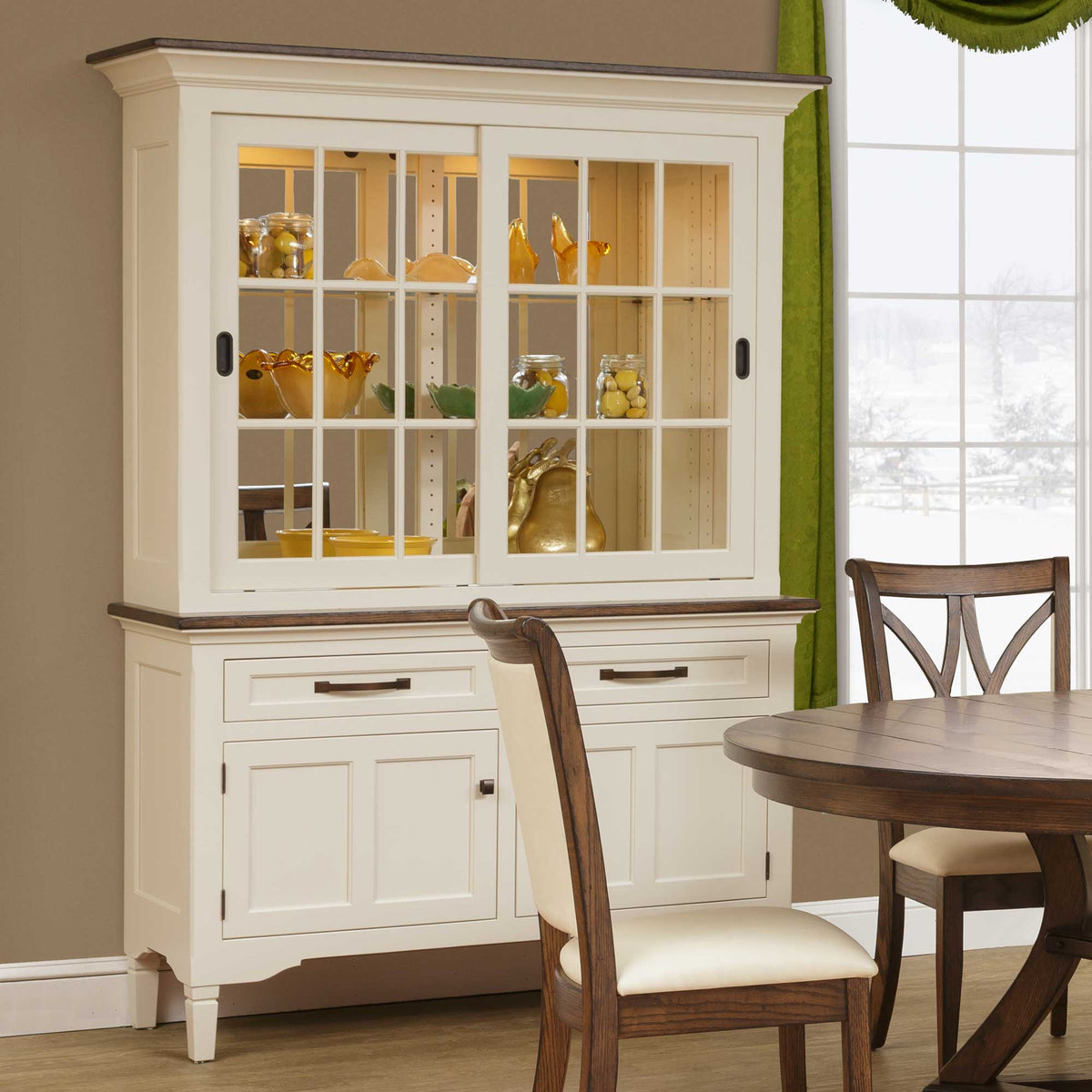 Cream painted china hutch with a driftwood top, lighted glass sliding doors and two drawers over paneled doors