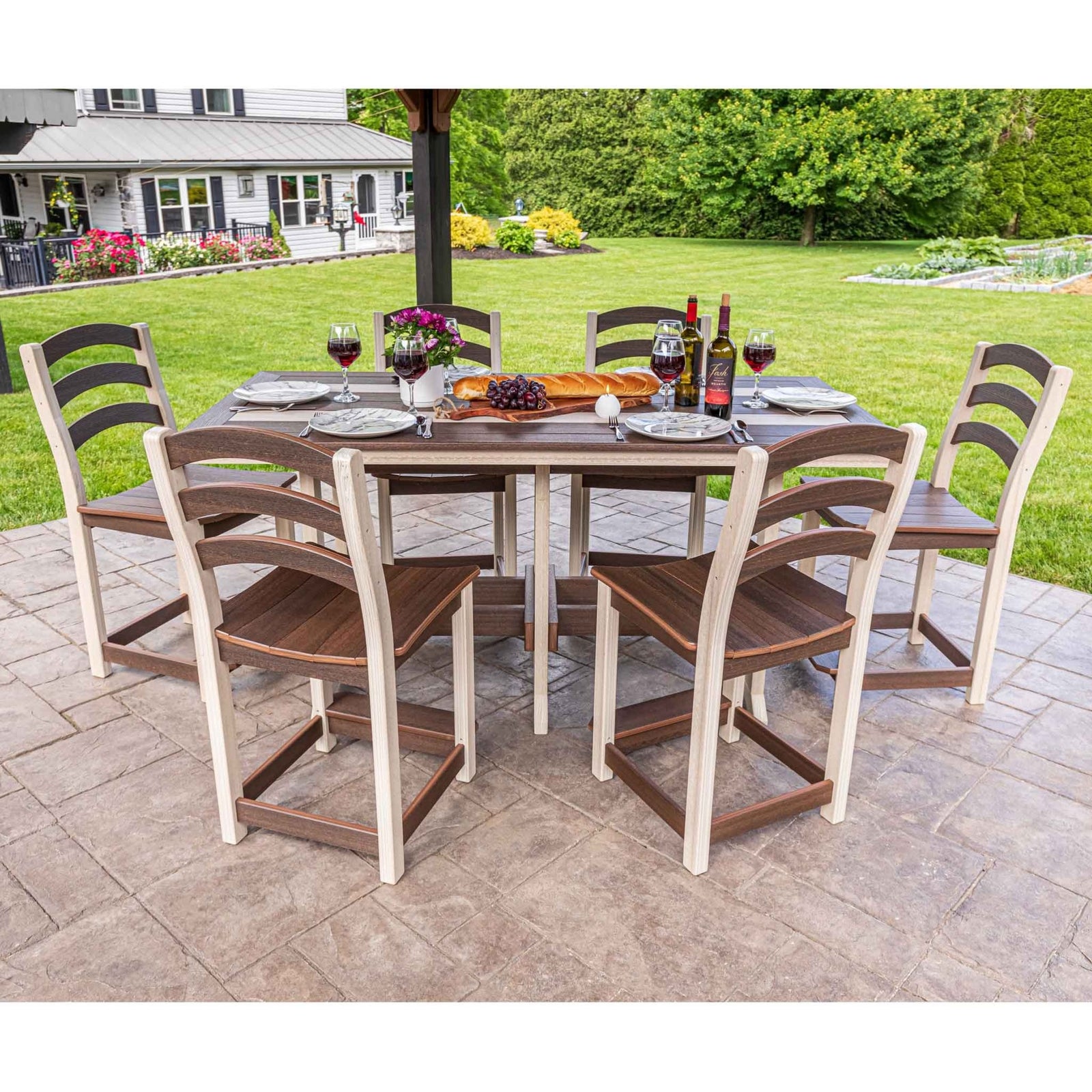 Weatherwood and brown poly counter height dining set with six ladderback chairs on a stamped patio