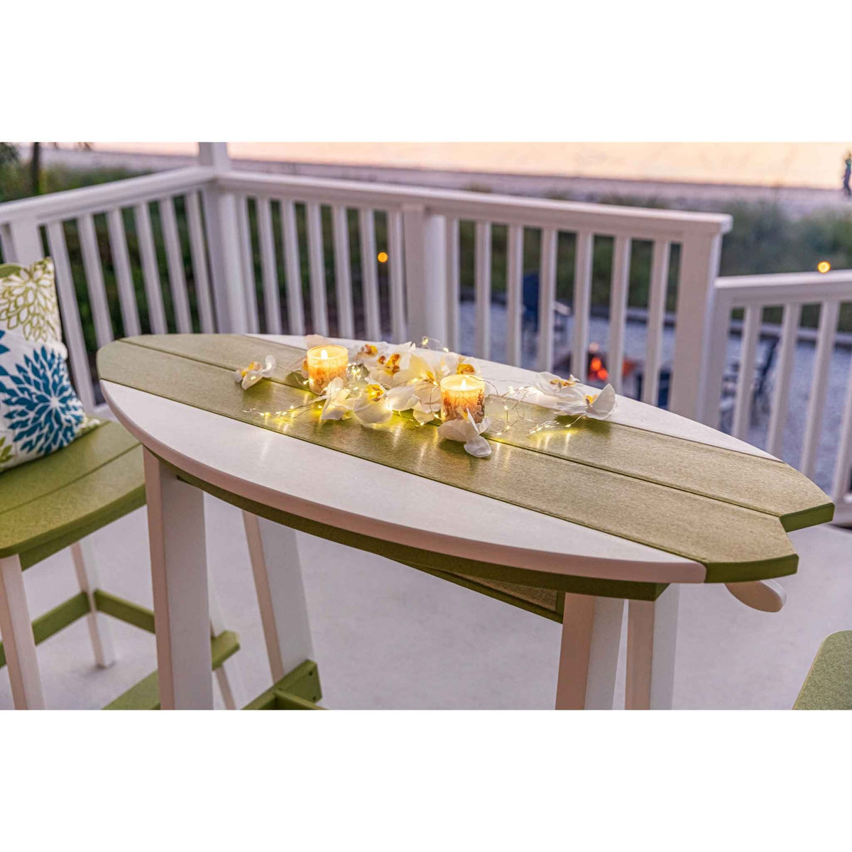 Close-up of the surfboard shaped poly counter table top with candles and orchids at dusk