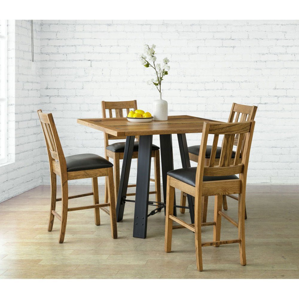 Reclaimed wood counter height table with four oak bar stools and black vinyl seats in a white brick corner
