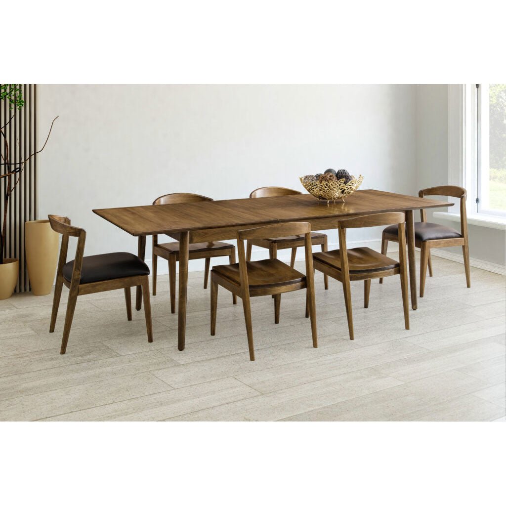 Extended walnut dining table set with six leather seat chairs in a bright minimalist dining room