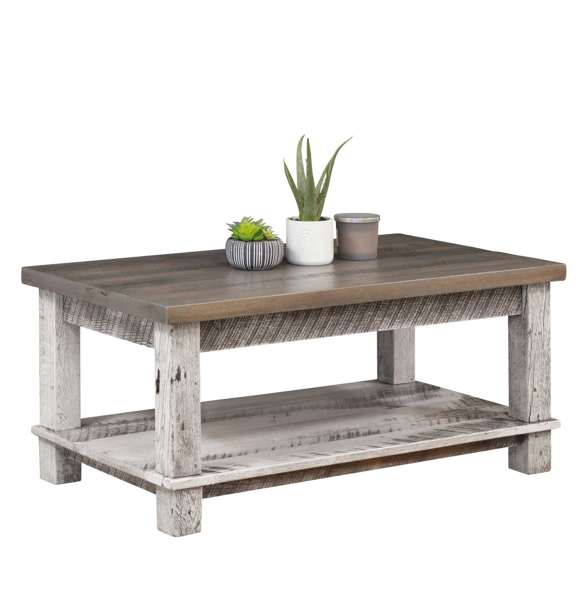 Rustic coffee table with a gray stained plank top, whitewashed chunky legs and a lower display shelf