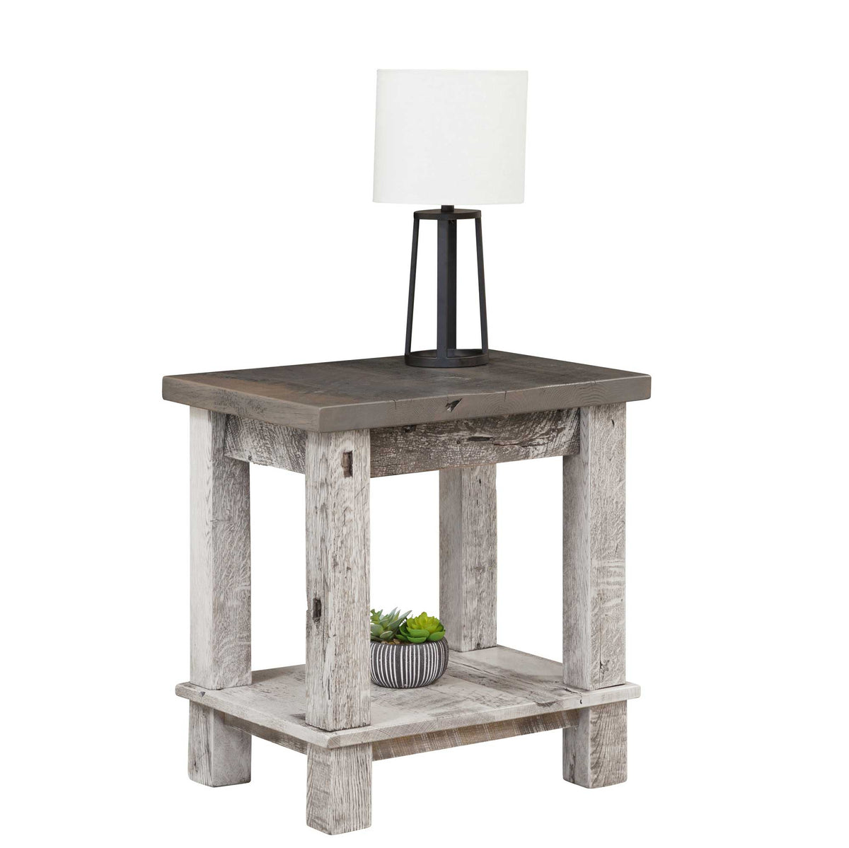 Reclaimed wood end table with a gray plank top, weathered white posts and an open bottom shelf holding a plant