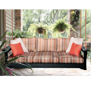 Black poly daybed porch swing hung on ropes with brown striped cushions and coral pillows on a stone patio