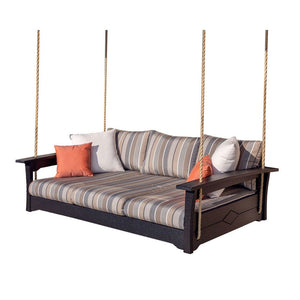 Black poly daybed swing suspended on ropes with gray striped cushions and orange accent pillow on a white background