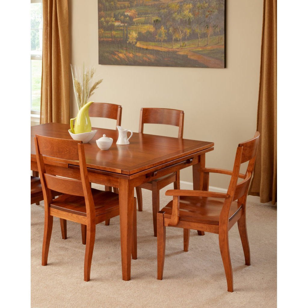 Cherry draw leaf extension dining table with curved back chairs and an arm chair in a carpeted dining room