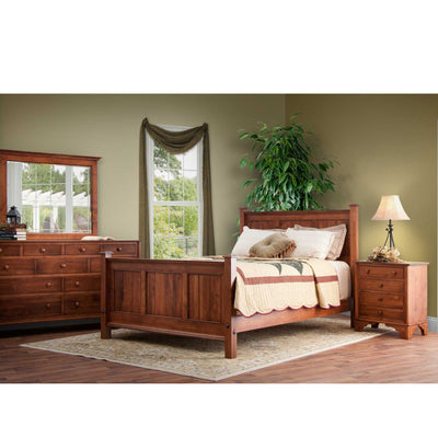 Cherry panel bed, nine-drawer dresser with mirror and nightstand staged in a bedroom with green walls