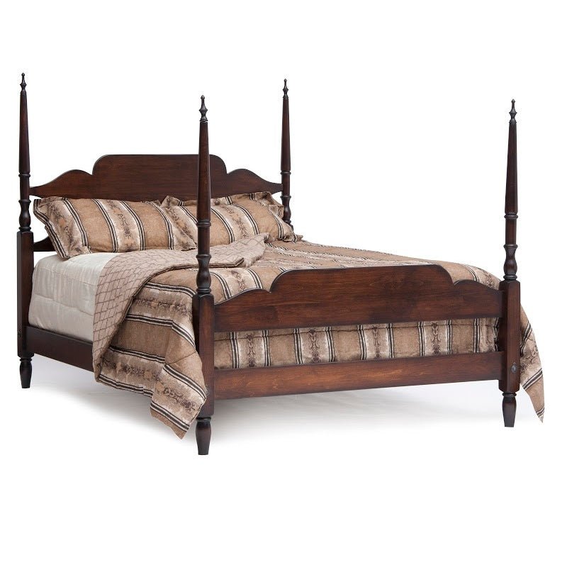 Dark cherry four-poster bed with turned finial posts, arched headboard, mirrored dresser and open nightstand in a bedroom