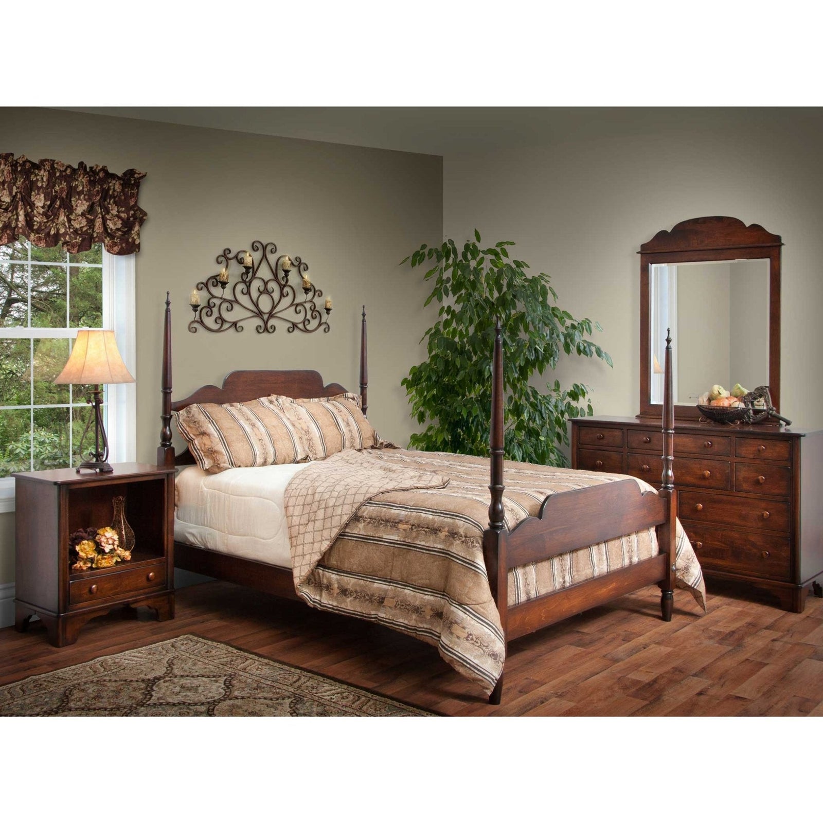 Dark cherry four-poster bed with turned finial posts, arched headboard, mirrored dresser and open nightstand in a bedroom