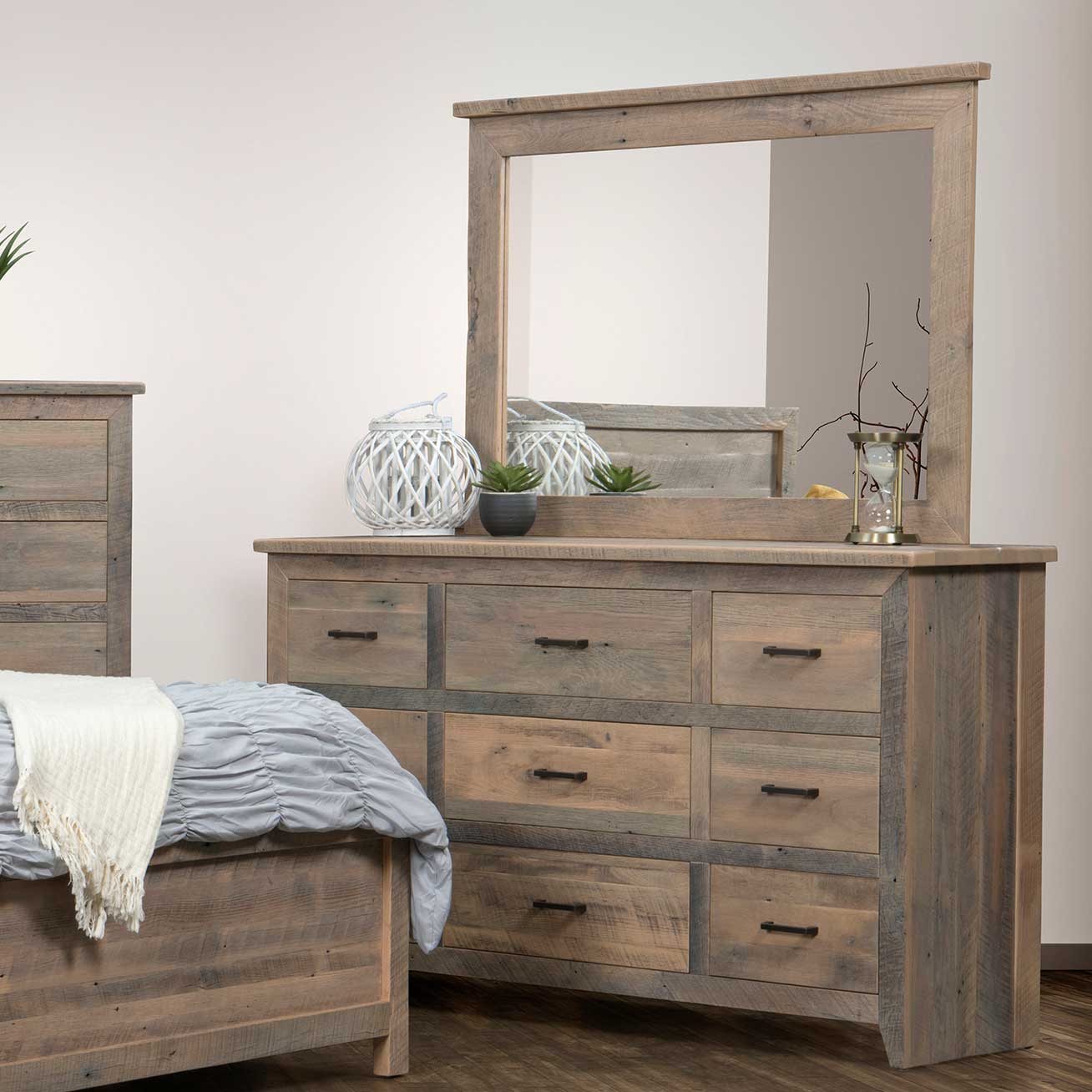 Weathered reclaimed wood dresser with nine drawers and mirror displaying a lantern, succulent and hourglass