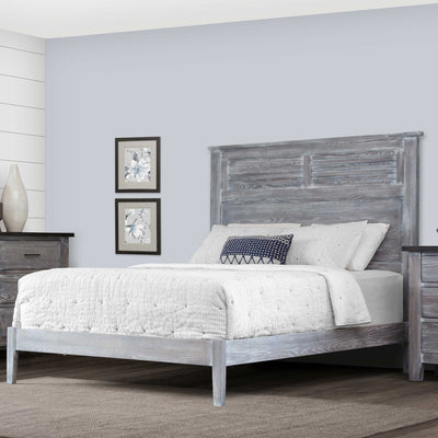 Weathered gray louver panel bed with a low footboard and white quilted bedding in a coastal styled bedroom