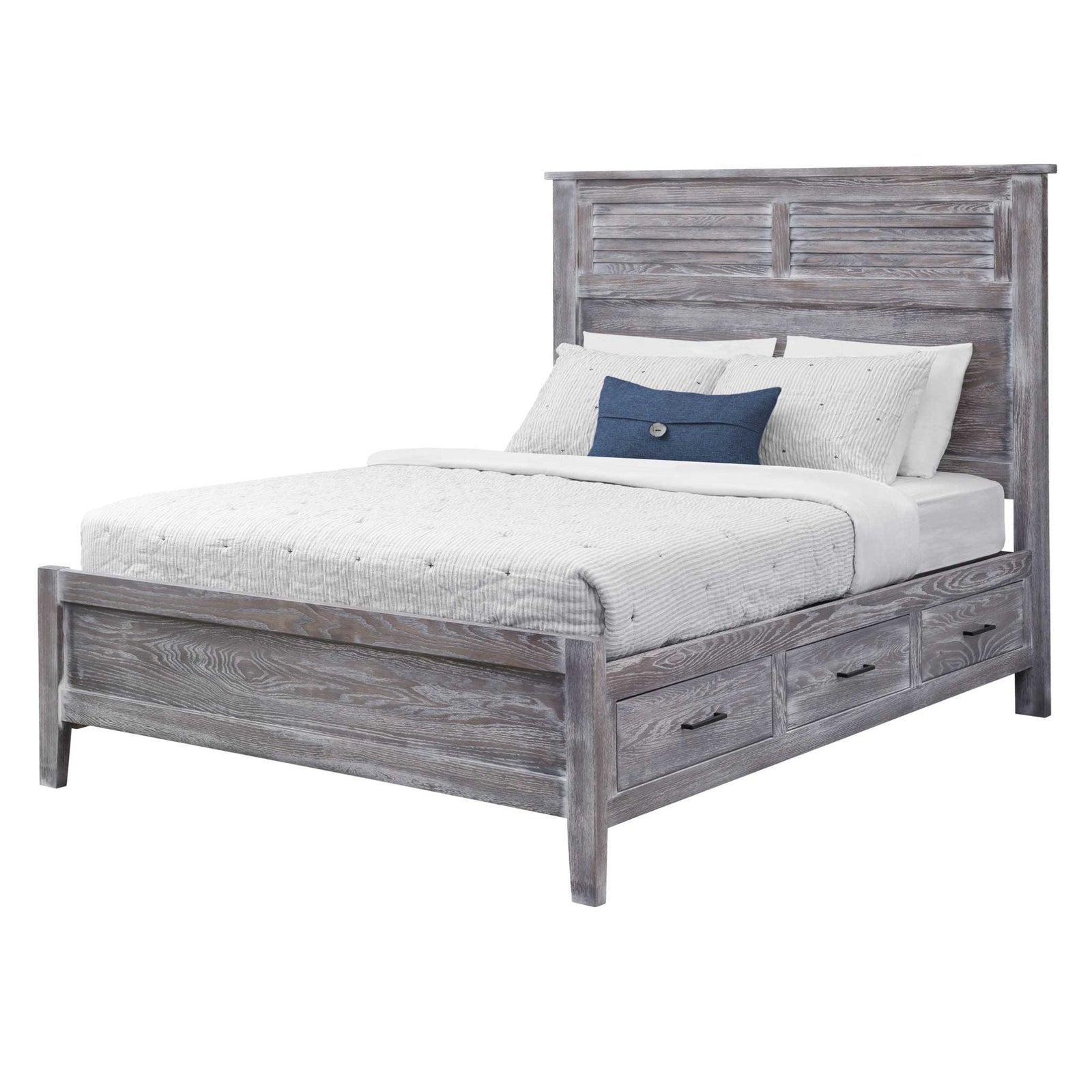 Weathered gray louver panel storage bed with three footboard drawers in a bright bedroom with dresser