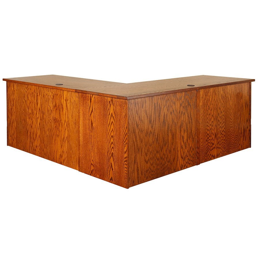 Rear view of the oak L shaped desk showing finished back panels, grommet holes and mitered corner top
