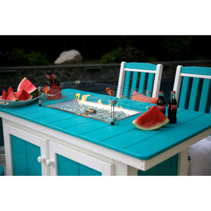 Close view of the turquoise poly fire pit island top with glass wind guard, lit burner and watermelon slices
