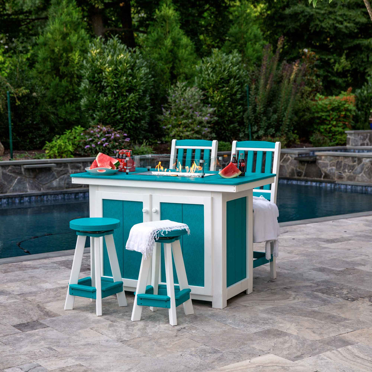 Aruba blue and white poly propane fire pit dining island with glass surround, two swivel stools and chairs by a pool