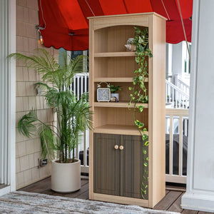 Light poly outdoor bookcase cabinet with three open shelves above two paneled doors, styled with plants on a porch