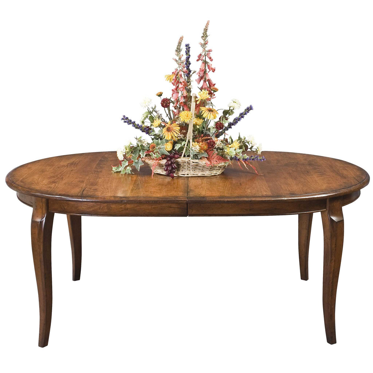 Oval extension dining table in warm oak with gracefully curved cabriole legs, styled with a flower basket