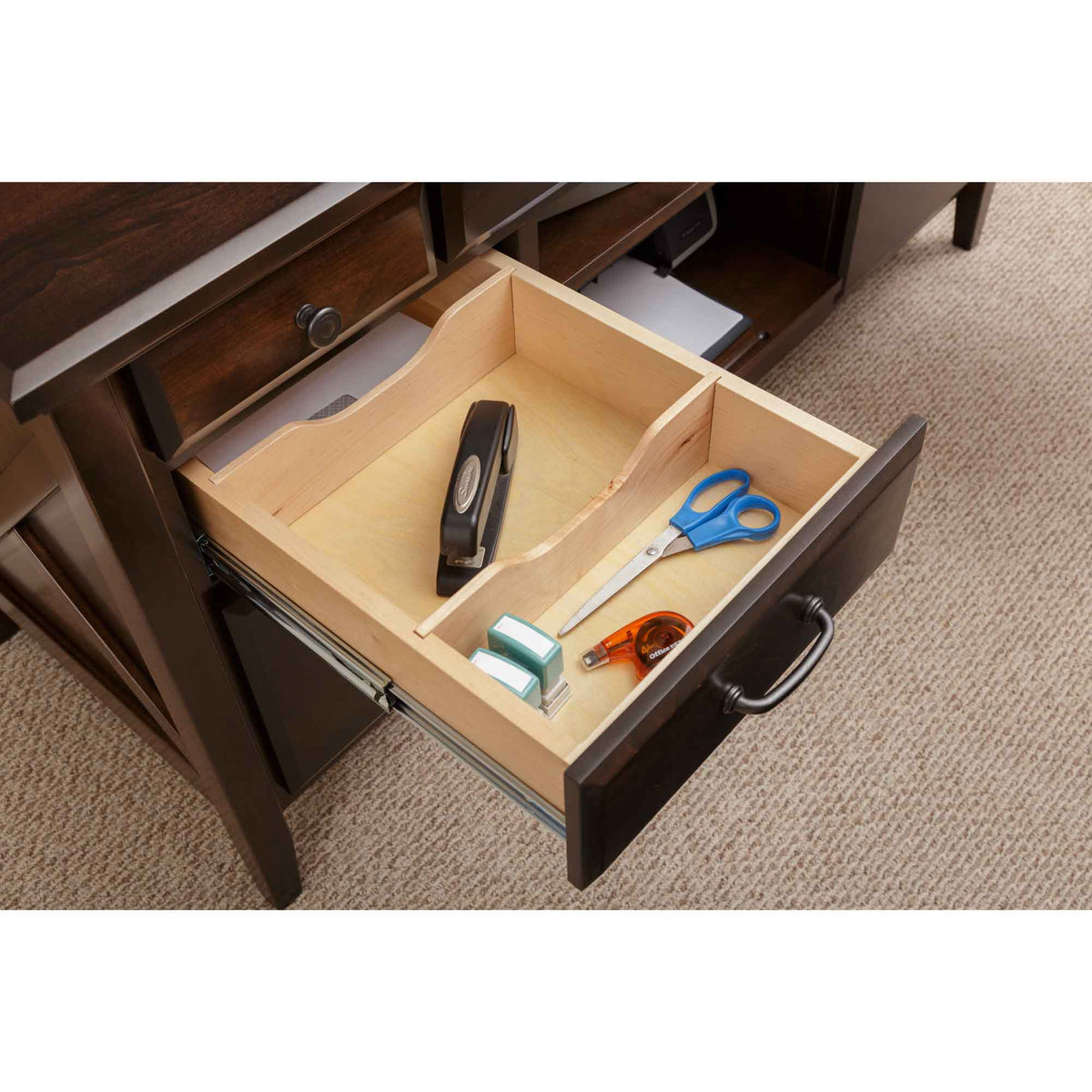 Center drawer of the credenza opened to a maple organizer tray with a stapler, scissors and tape