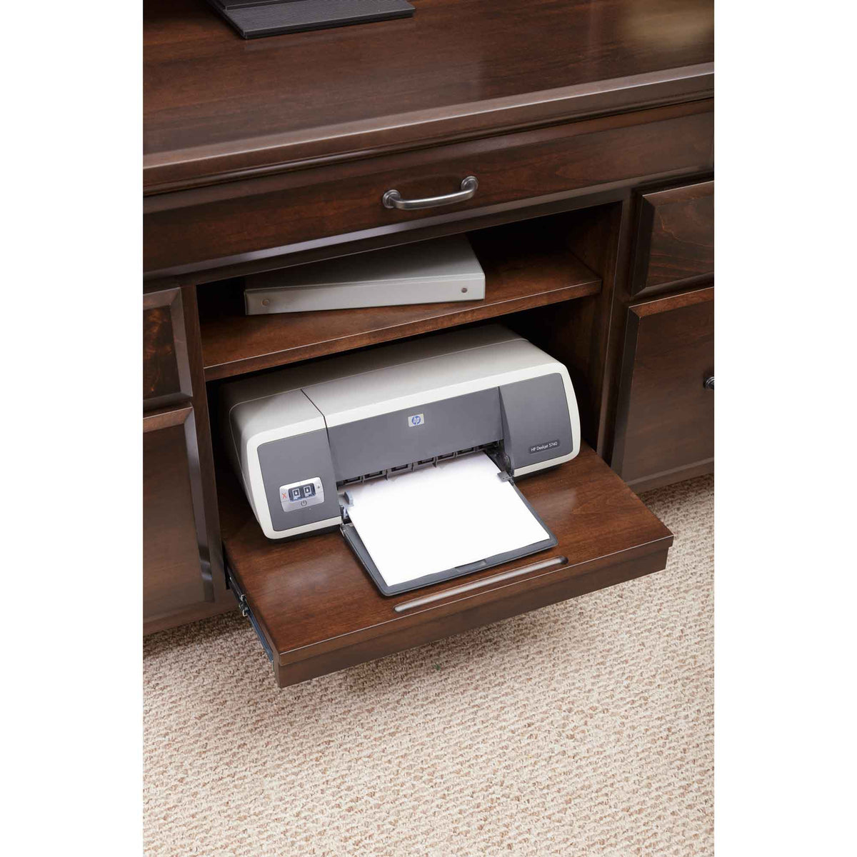 Sliding printer shelf pulled out from the credenza with an inkjet printer and a binder on the shelf above