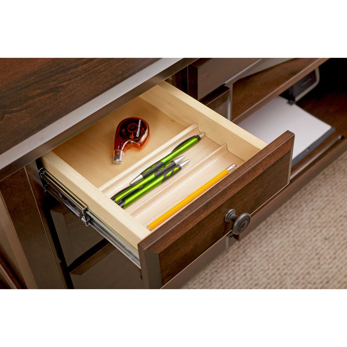 Shallow pencil drawer opened on the desk, revealing a maple tray with pens, a pencil and tape dispenser