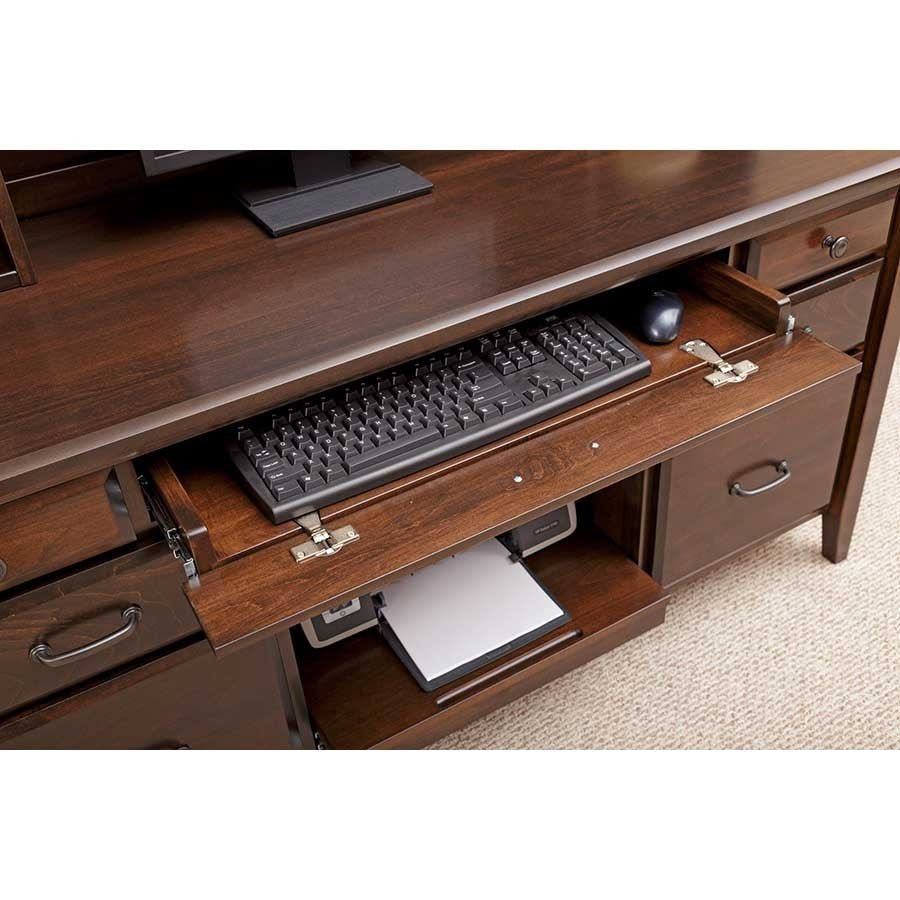 Pull-out keyboard shelf on the walnut credenza with keyboard and mouse, printer visible on the shelf below