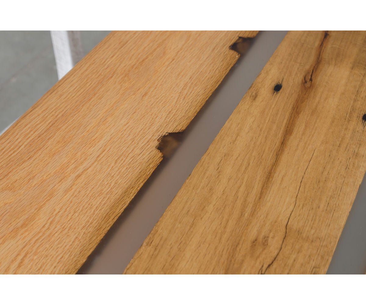 Two reclaimed oak boards with wormholes and knots divided by a poured gray resin channel