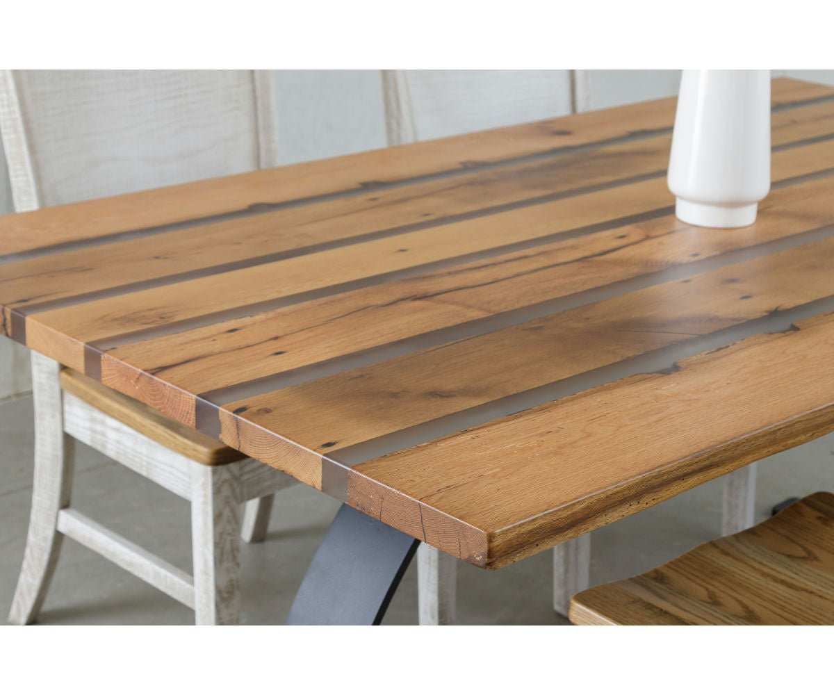 Angled corner shot of the resin striped reclaimed wood table with whitewashed chairs pulled up to it
