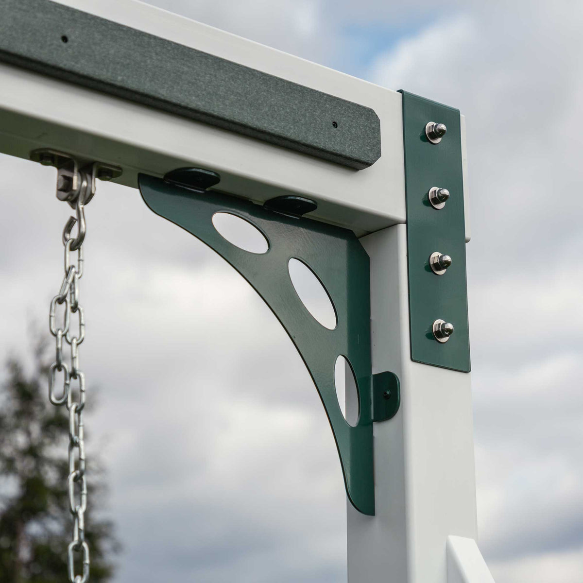 Detail of the green corner bracket and bolted swing beam of the vinyl playset with a swing chain hanging